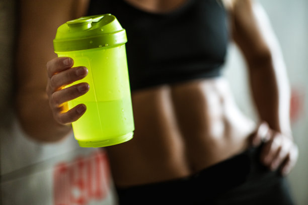 近距离看不出的运动女性在更衣室的水打破。图片下载