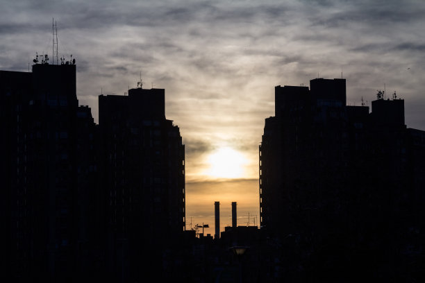 新贝尔格莱德郊区的传统共产主义住宅塔楼的形状，黄昏时分工业烟囱。这些高层建筑是野兽派建筑的象征图片下载