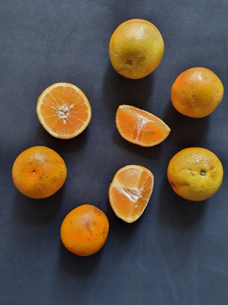 在黑色背景下，从上面看，整个和切好的橘子图片下载