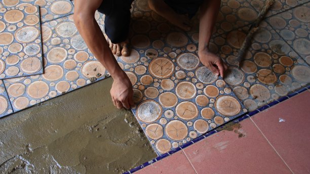 建筑工人在地板上安装瓷砖时图片下载