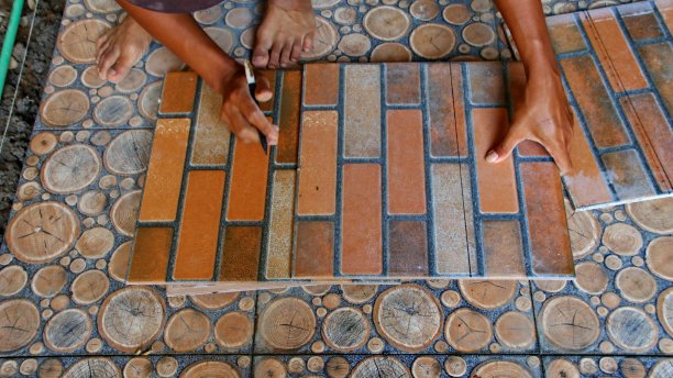 建筑工人在地板上安装瓷砖时图片下载