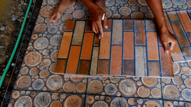 建筑工人在地板上安装瓷砖时图片下载