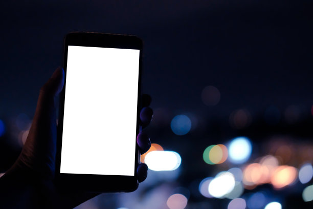 手持移动智能手机与散景夜灯图片下载