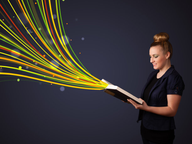 漂亮的年轻女子读一本书，而彩色的线条正在走出书图片下载