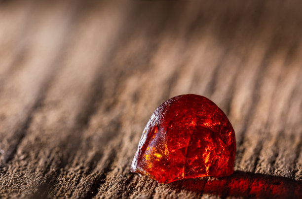 天然琥珀。一片黄色透明的天然琥珀，镶嵌在大块深色的石头上。图片下载