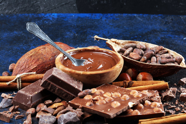 巧克力块和融化的漩涡可可。甜食照片的概念。桌上的大块碎巧克力图片下载