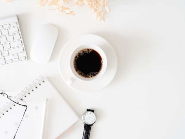 顶视图的办公桌桌子与咖啡杯和笔记本在白色的背景，平面设计师，创意设计师的概念。图片下载