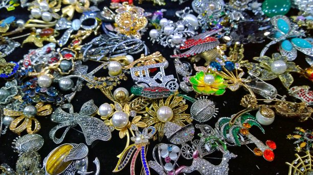 手工珠宝为妇女和女孩从珠子，珍珠，银和黄金，人工宝石在黑色的背景。适合女性的时尚饰品、吊坠、胸针、发夹、手镯等。图片下载