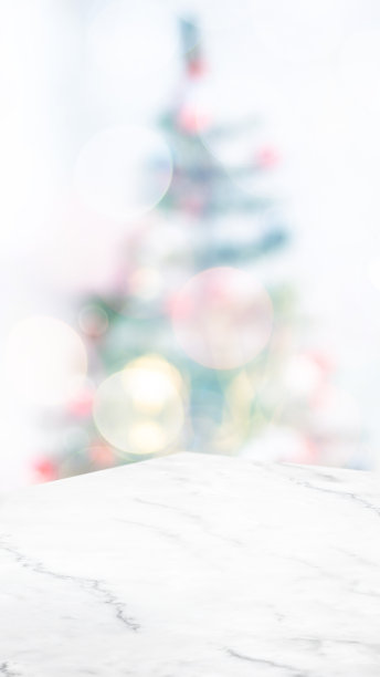 空白的白色大理石桌面，抽象的圣诞树装饰，灯光模糊的背景，假日背景，产品展示和在线媒体广告的垂直横幅模型。比率16:9。图片下载