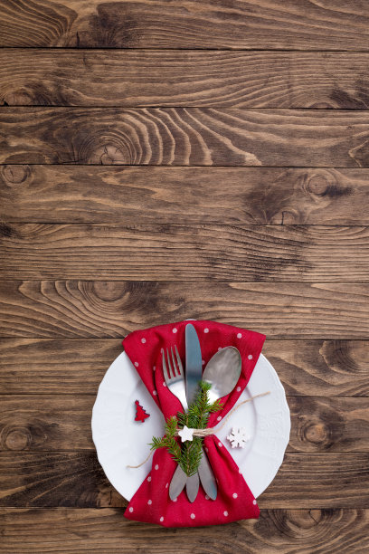 圣诞餐桌的地方设置红色和白色的圆点餐巾在木制的背景图片下载