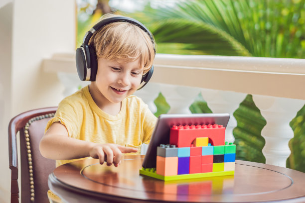 热带地区的男孩用平板电脑和无线耳机与朋友和家人进行视频通话图片下载