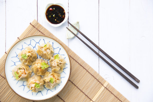 广东点心。鲜虾包黄饺子，蒸中国包黄饺子。白色木地板背景，空间。中国流行的点心食品。图片下载