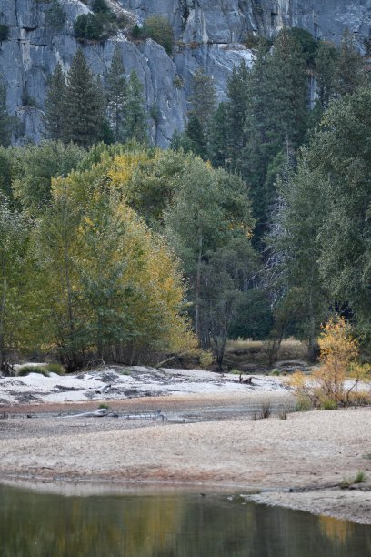 树木反射在弯曲的溪流与秋天的颜色和花岗岩悬崖图片下载