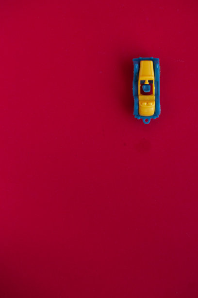 红色背景上的玩具车的照片。图片下载