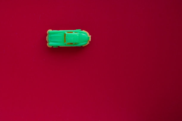 红色背景上的玩具车的照片。图片下载