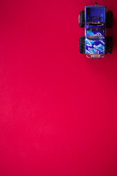 红色背景上的玩具车的照片。图片下载