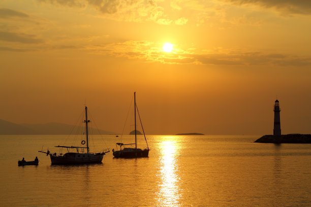 在夕阳海景。海岸上的灯塔。海边小镇Turgutreis和壮观的日落图片下载