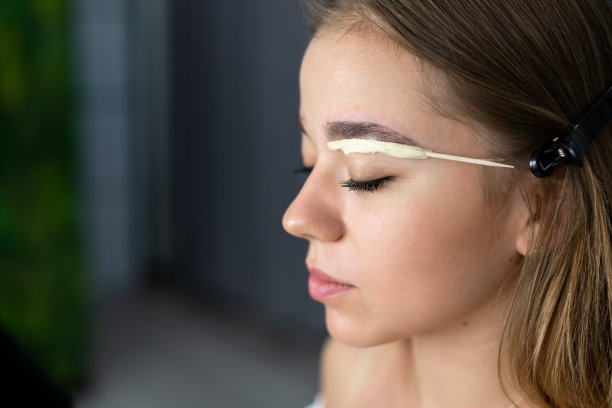 年轻的美容师白种女孩持有模特的眉毛矫正图片下载