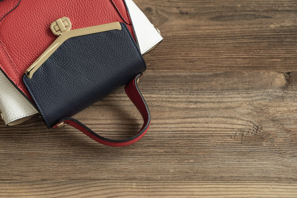 色彩鲜艳的时尚皮包在木质背景上，俯视图，拷贝空间。图片下载