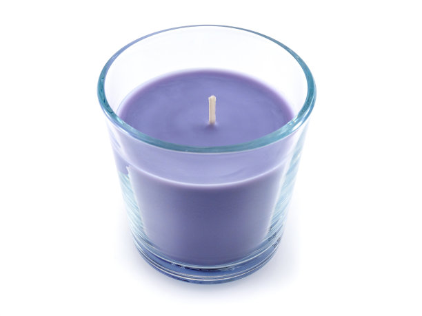 白色背景上的玻璃杯里的紫色蜡烛图片下载