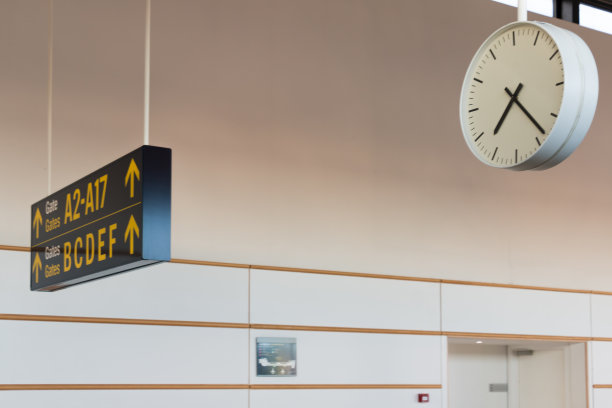 机场航站楼内指示登机门和时钟的面板图片下载