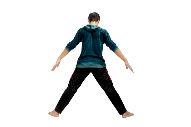 全长度的镜头男性青少年做伸展运动孤立在白色通过展开他的手足够宽。男性做积极运动。活跃的男性构成。图片下载