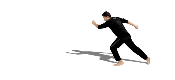 全身像拍摄的男性青少年做积极的锻炼。男运动员在运动服孤立和给予跑步姿势。男性孤立伸展双腿。活跃的姿势。用阴影水平拍摄。图片下载