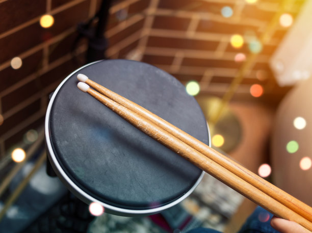 鼓和木制鼓槌的模糊图像。女孩在音乐室学习架子鼓，演奏乐器的概念。图片下载