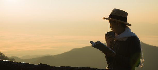 亚洲妇女站在那里，阅读着美丽的自然景色图片下载