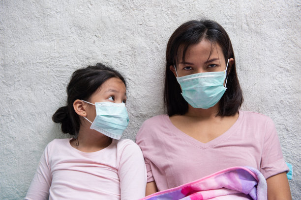 亚洲年轻的母亲和孩子的女儿戴着防护面具图片下载
