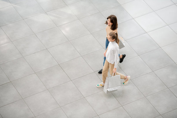 当代的购物狂背着袋子沿着大型贸易中心移动图片下载