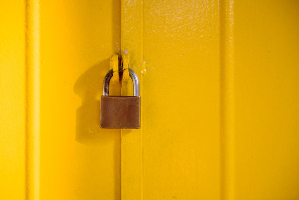 黄铜挂锁和黄色金属门图片下载