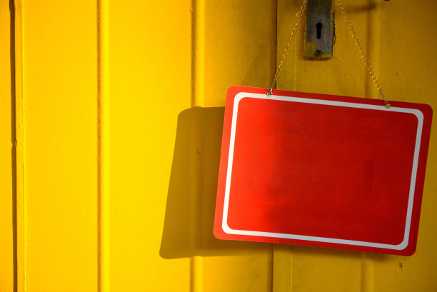 红色的布告栏挂在彩色的门上图片下载