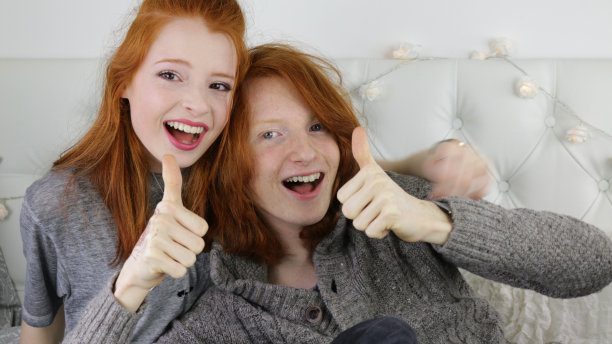 照片中，一个14 / 15岁、皮肤苍白、长着雀斑的红发少女坐在卧室里，旁边是她16 / 17岁的姜黄色头发的弟弟，看着镜头微笑着四处嬉戏，男孩和他的妹妹对着镜头竖起大拇指图片下载