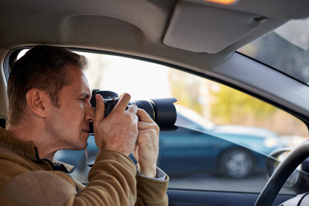 一个开车带着单反相机的年轻人。图片下载