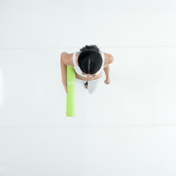 一个人/全身/直接俯瞰/鸟瞰图20-29岁的成年人美丽的黑发/长发白人女性/年轻女性准备瑜伽/走在白色背景和使用练习垫图片下载