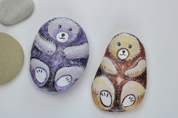 在白纸背景上绘有两只熊形的石头图片下载