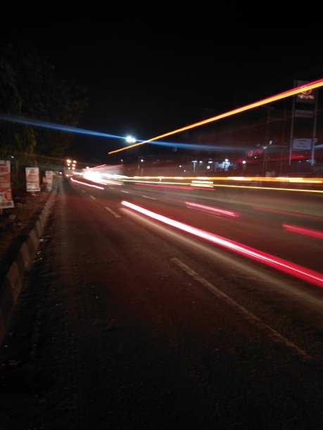 城市夜晚灯光的抽象透视被汽车的速度所遮蔽。光行脚印。散焦图片下载