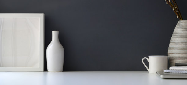 现代的工作空间，模拟框架和陶瓷花瓶在白色的桌子和灰色的墙壁背景图片下载