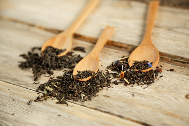 不同品种的天然茶在竹匙上在一个木制的背景图片下载