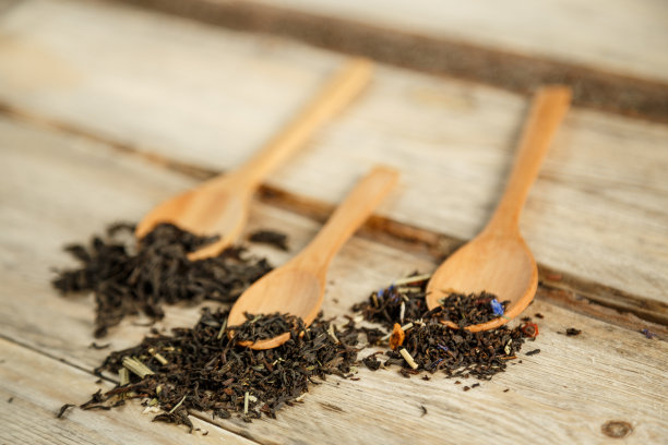 不同品种的天然茶在竹匙上在一个木制的背景图片下载
