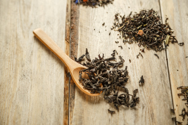 不同品种的天然茶在竹匙上在一个木制的背景图片下载