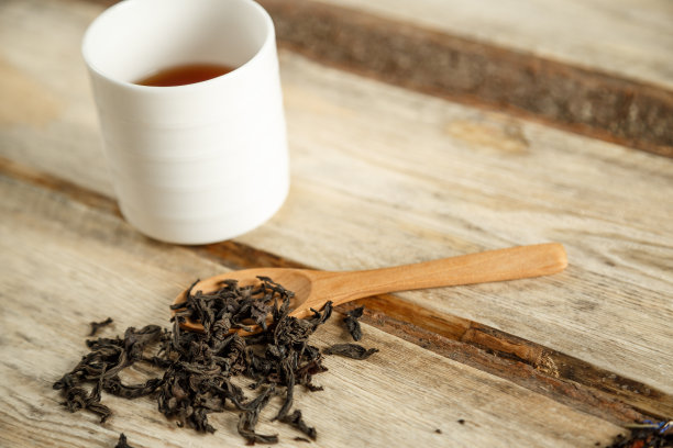 不同品种的天然茶在勺子和冲泡在一个木制背景的杯子。从上往下看图片下载