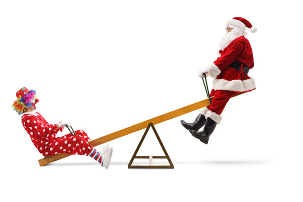 快乐的圣诞老人和小丑在跷跷板上图片下载