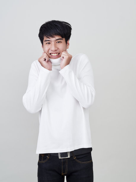 工作室肖像的年轻亚洲男子穿着白色的毛衣在白色的背景。图片下载