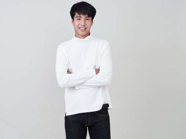 工作室肖像的年轻亚洲男子穿着白色的毛衣在白色的背景。图片下载