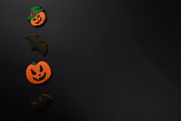 手工制作的可食用姜饼万圣节南瓜和蝙蝠的黑色背景图片下载