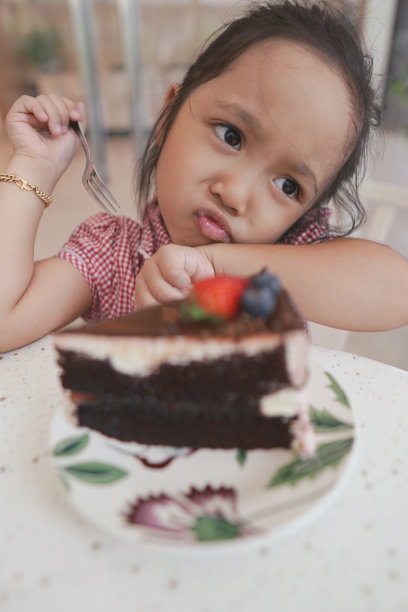 可爱的亚洲女孩享受她的蛋糕图片下载