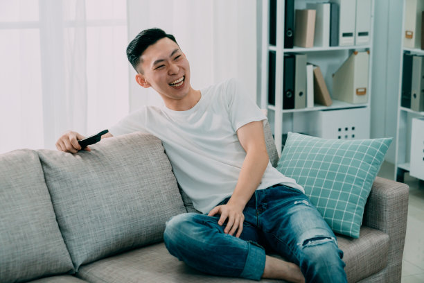 男人看着电视搞笑的节目笑了图片下载