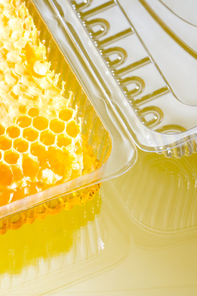 蜂房与蜂蜜在一个塑料容器特写图片下载